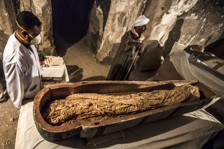 November 24, 2018: Egyptian craftsmen and archaeologists stand next to an intact, open sarcophagus containing the well-preserved mummy of a woman named "Thuya", discovered in the Al-Assassif necropolis in Luxor, Egypt.
