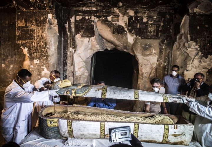 Egyptian Minister of Antiquities, Khaled el-Enany (2nd row) and Mostafa Waziri (behind, C), secretary-general of the Supreme Council of Antiquities, inspect an intact sarcophagus during its inauguration on the site of the tomb TT33 in the Egyptian city South Luxor.