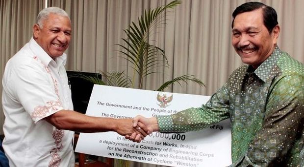 Fiji Prime Minister Frank Bainimarama receives a 5 million US dollar cheque from Indonesia's Coordinating Political, Legal and Security Affairs Minister Luhut Pandjaitan.