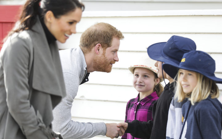 Prince Harry and Meghan talk to schoolchildren outside the Maranui café. 