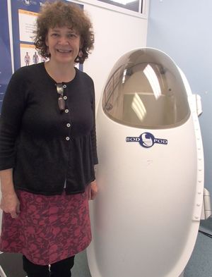 Jane Coad next to the Bod Pod for measuring human body fat