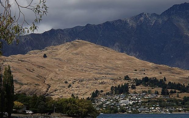 View from Queenstown to  the Remarkable Range showing numerous small wilding pines spreading across Kelvin Heights