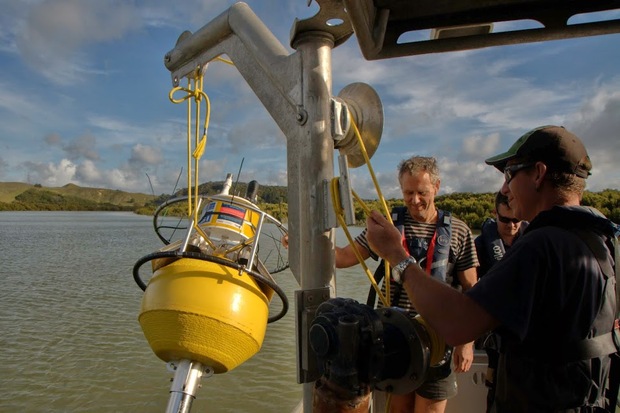 Lowering an estuarine monitoring buoy over the side of a boat