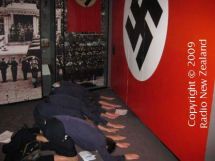 Students bow down in front of a Nazi flag.
