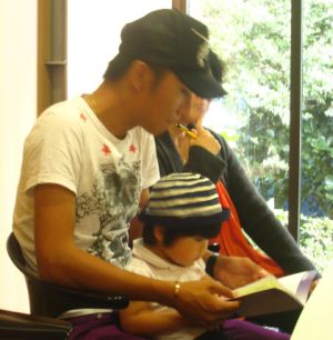 A father and his young daughter attending a Chinese parenting lecture