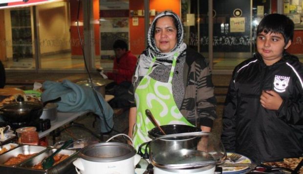 Zarghouneh and her year old nephew serve at the food stall for Afghanistan