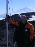Criag Rodger with the radio aerial at Arrival Heights, Mount Eerebus in the background