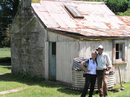 Karen McLeay and Bruce Watkins standing outside the stone kitchen, South Waikato
